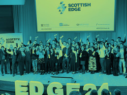 A gathering of people on stage celebrating their EDGE Round 24 Success
